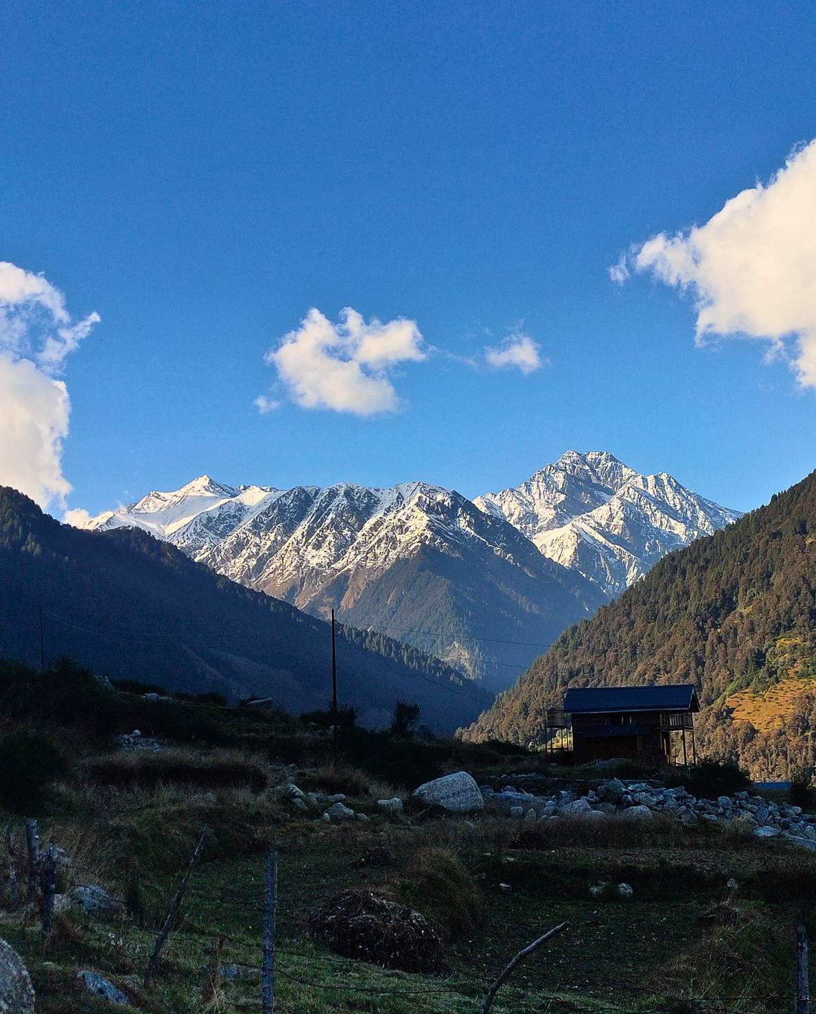 Dhauladhar range at golden hour with a mountain homestay in the Rajgundha valley